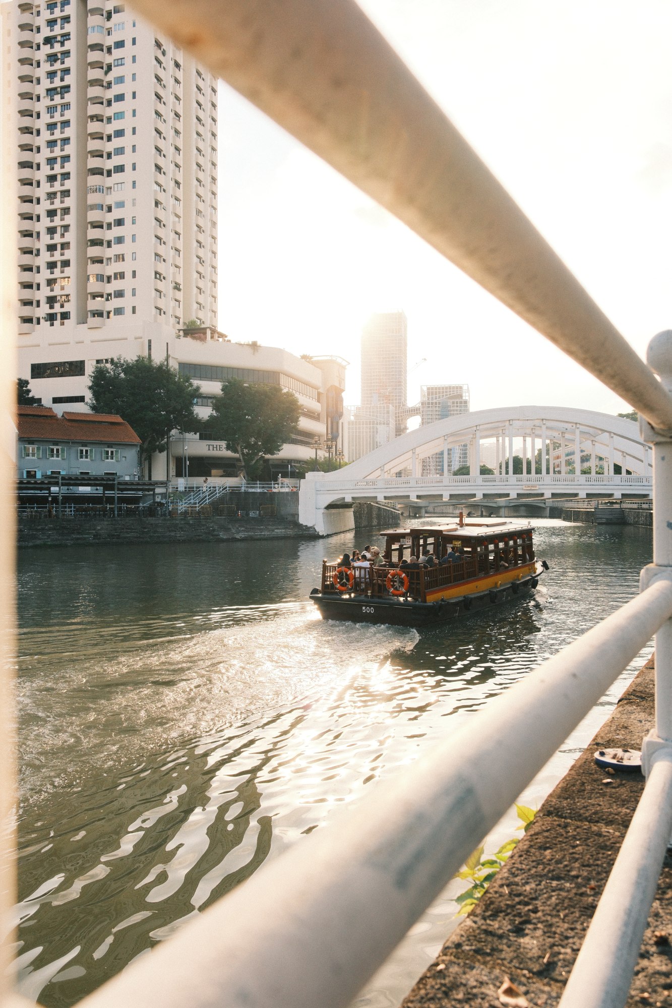 A boat beneath a city bridge